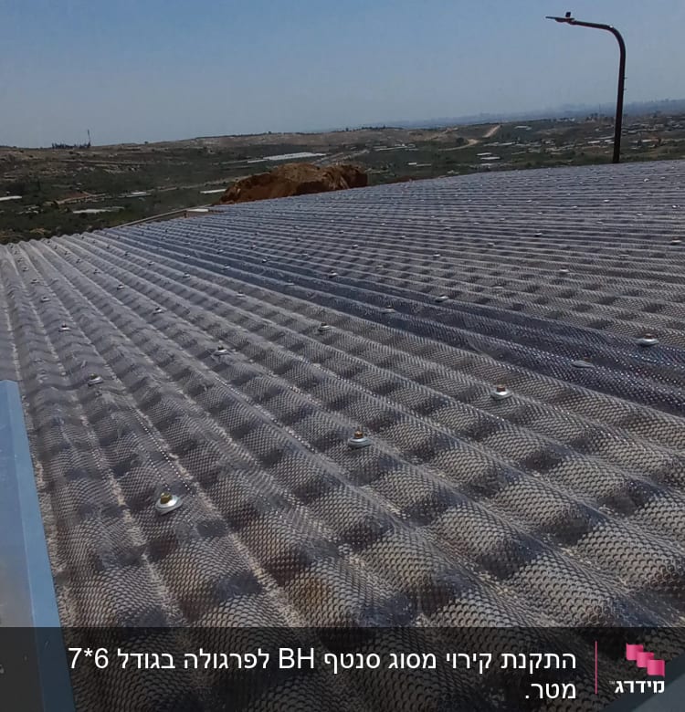 גג מתכת עם ברגים ונוף ברקע